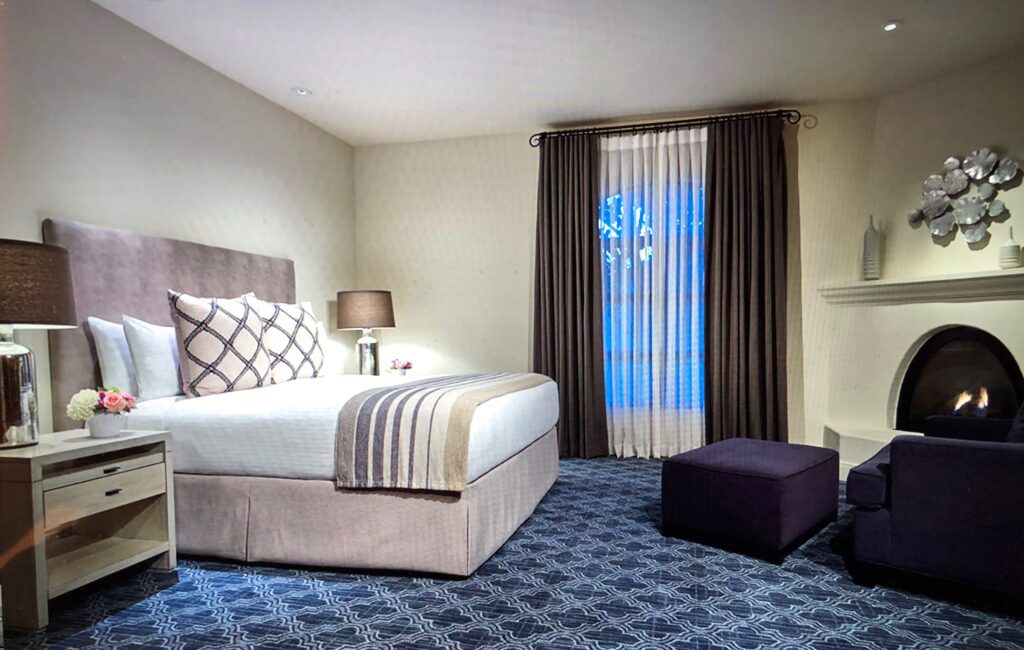 A bedroom with a bed, window and chair.