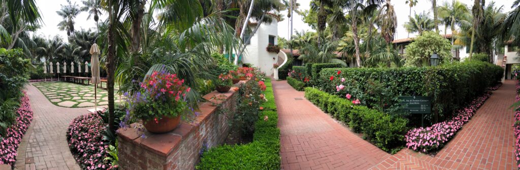 A walkway with bushes and flowers in it