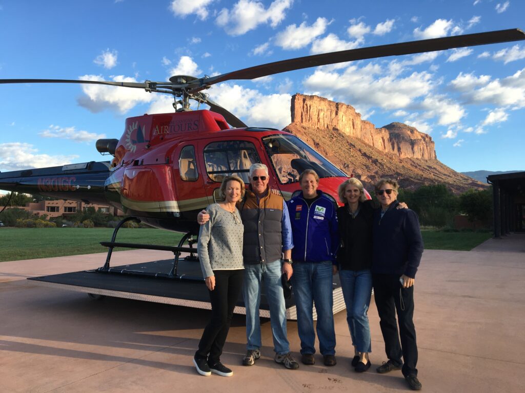 A group of people standing in front of a helicopter.